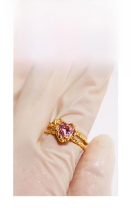 Detail view of heart-shaped pink zircon ring with textured gold-tone lava finish band
