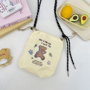 Detail of cream yellow canvas bucket bag with bear embroidery and adjustable strap