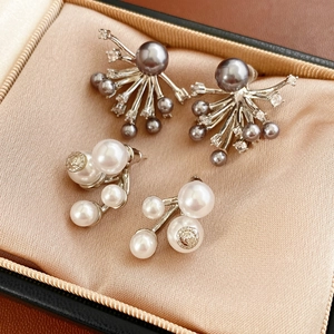 Macro detail of luxury pearl earrings with crystal accents in a velvet jewelry box