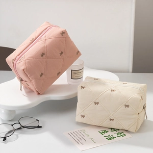 Quilted bow-knot cosmetic bags in pink and beige colors for travel and toiletries