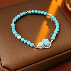 Detail of turquoise gourd pendant on beaded bracelet with silver spacers and zircon stones