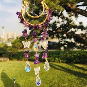 Detail of amethyst chips and butterfly beads on moon suncatcher in natural light