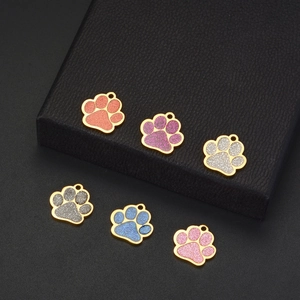 Macro shot of glitter-filled paw prints pet tags in pink, purple, and blue with gold edges