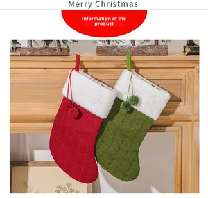 Close-up of knit Christmas stockings with plush trim and pom-poms by a fireplace