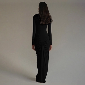 Detail of the gathered pleat design on the back of a slim fit black maxi dress