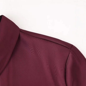Primer plano de camisa de satén burdeos mostrando la textura fina y costuras del cuello