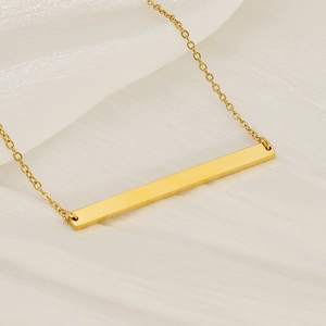 Minimalist gold titanium steel necklace featuring a sleek rectangular bar pendant on silk