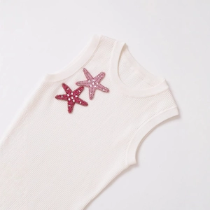 White ribbed knit sleeveless top featuring pink sequined starfish embroidery on white backdrop