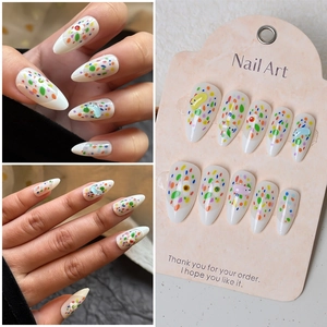 Detail of almond almond-shaped press-on nails with 3D bear charms and colorful polka dots