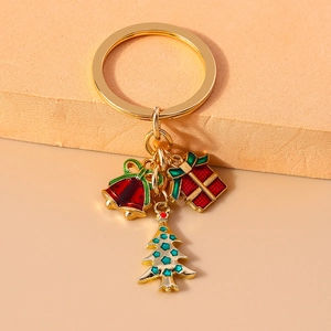 Detailed view of Christmas keychain with gold tree, bell, and gift box charms