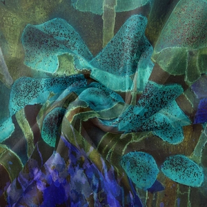Detail of bohemian tapestry fabric showing soft texture and abstract blue green ink pattern