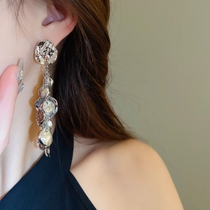 Gros plan de boucles d'oreilles argentées à pampilles sur un mannequin