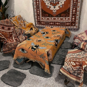 Bohemian orange picnic blanket with bee and floral patterns and decorative tassels