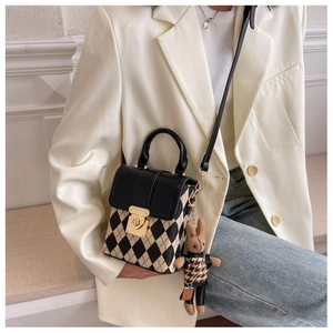 Detail showing beige quilted crossbody bag with gold lock and cute bunny doll charm