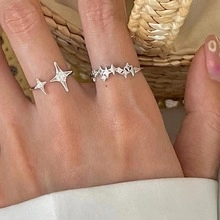 Detail shot of silver star-shaped open ring and multi-star band for women