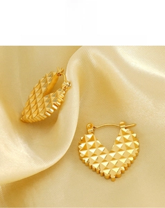 Macro detail of 18K gold-plated heart earrings with geometric pyramid texture finish