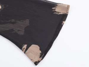 Detailed macro view of chiffon fabric with brushstroke print and stitched sleeve cuff