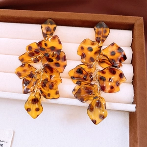 Detail of leopard print acrylic petal earrings with gold links and layered tassel style