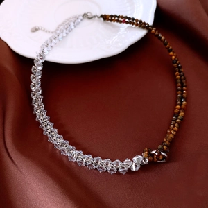 Détail de collier avec cristaux facettés et pierres œil de tigre sur soie brune
