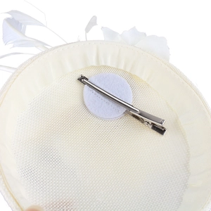 Detail view of the metal hair clip and felt base on the beige fascinator pillbox hat