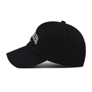 Close-up of white Fearless embroidery on black cotton twill baseball cap side