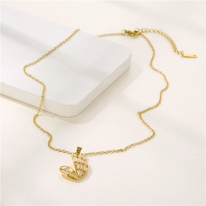 Elegant gold heart necklace with zircon inlay on a minimalist geometric display
