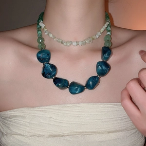 Detail view of bohemian double-layer necklace with blue marble beads and green stones