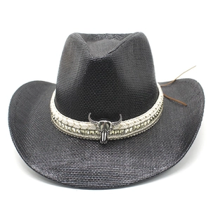 Close-up of black straw cowboy hat featuring a silver bull skull metal buckle and studs