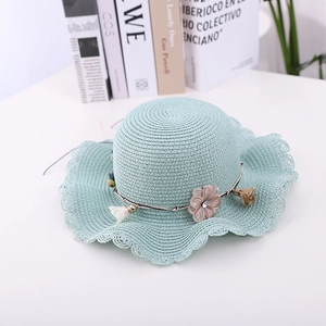 Detailed straw weave texture of mint green sun hat with fabric flower and metal chain