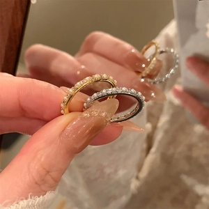 Detailed close-up of gold and silver plated rings with pearls and zircon in a mirror
