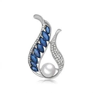 Detailed macro view of a silver floral brooch with blue stones and a large white pearl