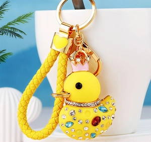 Detail of yellow duck keychain with colorful rhinestones and woven leather strap