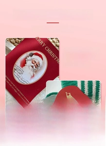 Dettaglio del biglietto di Natale con Babbo Natale e cartellino a forma di mela rossa