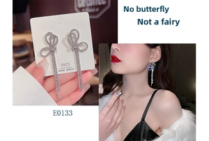 Detail of silver S925 bowknot tassel earrings with rhinestones on model and card
