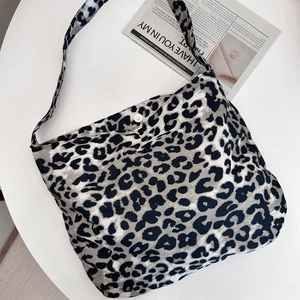 Detail of large canvas tote bag showing black and white leopard print and magnetic closure