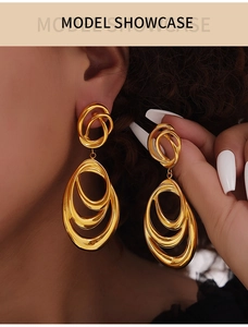 Detail of layered geometric gold hoop earrings featuring polished nesting metal rings
