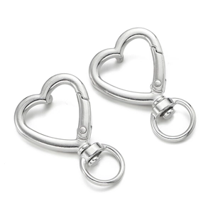 Detail view of two silver heart-shaped lobster clasps for DIY keychains and bag charms