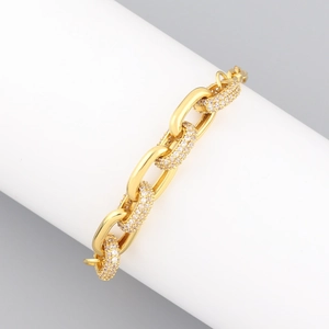 Macro detail of gold-plated hip hop chain bracelet featuring pavé set white zircon stones
