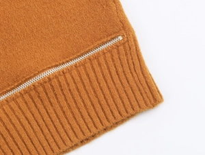 Détail du pull en maille camel avec fermeture éclair argentée et texture côtelée fine