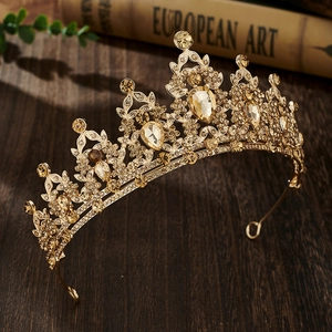 Detailed macro view of golden bridal crown with amber rhinestones and leaf pattern design