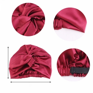 Detail view of burgundy satin sleep cap showing knot design, double layer, and elastic band