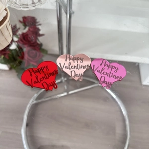 Close-up of red, rose gold and pink acrylic heart cupcake toppers with Happy Valentine's Day