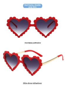 Detail der roten herzförmigen Sonnenbrille mit Wellenrand und goldenen Metallbügeln