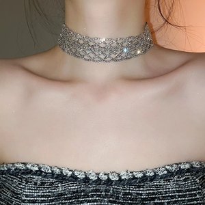 Vue macro du collier ras du cou en strass argentés sur le cou pour un look de fête élégant