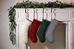 Detailed knit texture of four classic Christmas stockings in white red green and gray