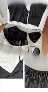 Detail of black satin sleepwear set showing V-neck camisole, shorts, and eye mask texture