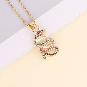 Macro shot of 18K gold snake pendant with vibrant multi-color zircon stones on book