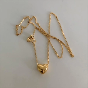 Polished gold heart pendant necklace with fine chain and two small heart charms