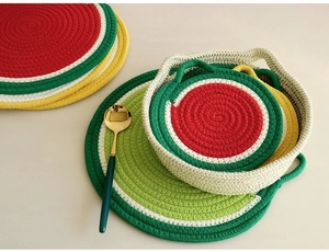 Detailed macro view of fruit-themed cotton rope placemats and a woven storage basket