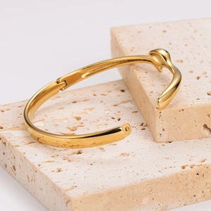 Detailed macro view of gold-plated snake snake ring showing green enamel eye and smooth finish